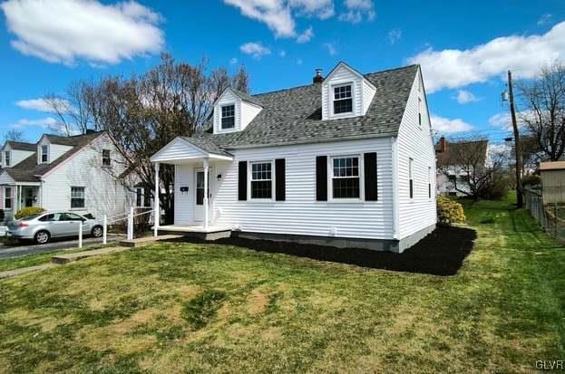 cape cod-style house featuring a front lawn