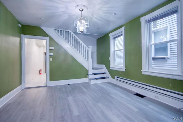 interior space featuring a notable chandelier, wood-type flooring, and a baseboard radiator