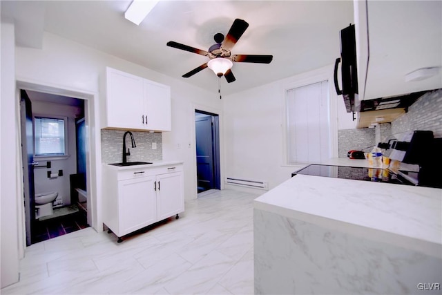 kitchen with white cabinetry, sink, a baseboard radiator, tasteful backsplash, and stove