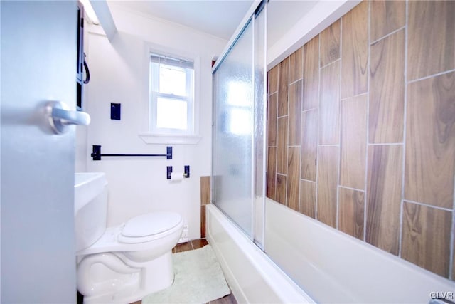 bathroom featuring shower / bath combination with glass door, hardwood / wood-style floors, and toilet