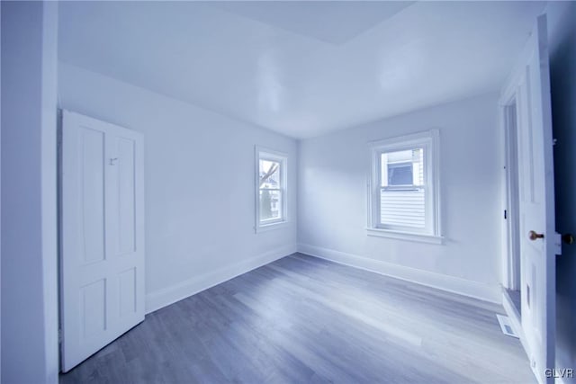 spare room with plenty of natural light and dark wood-type flooring