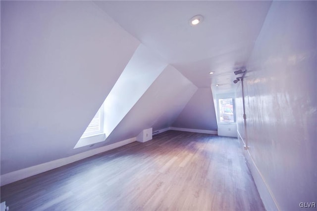 additional living space with hardwood / wood-style flooring and lofted ceiling