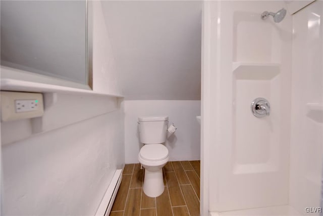 bathroom featuring a shower, vaulted ceiling, toilet, and a baseboard heating unit