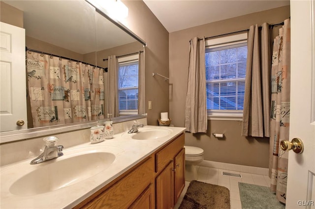 bathroom with toilet, visible vents, a sink, and tile patterned floors