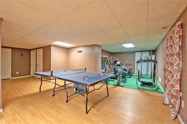 game room featuring a paneled ceiling, visible vents, baseboards, and wood finished floors