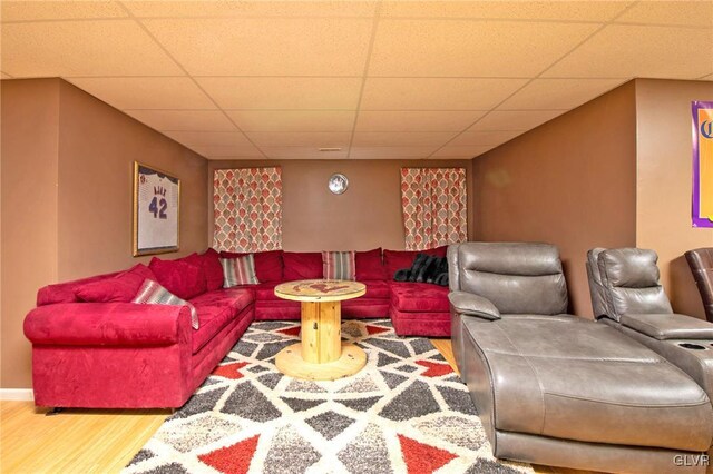 living area featuring a paneled ceiling and wood finished floors