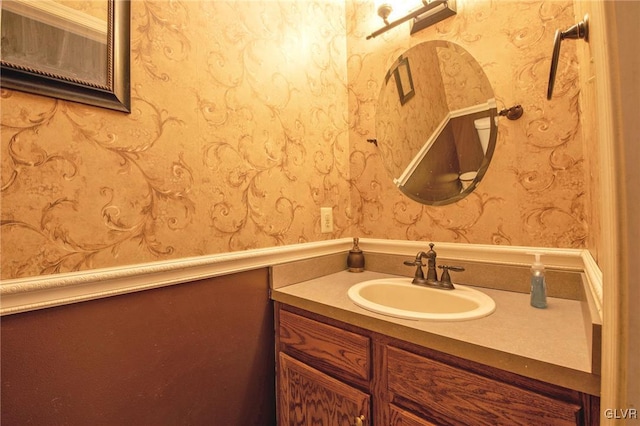 bathroom with vanity and wallpapered walls