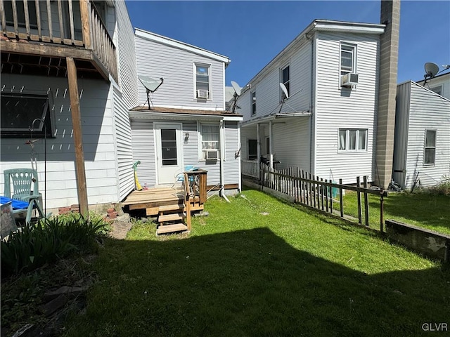 rear view of house with a lawn, cooling unit, and a wooden deck