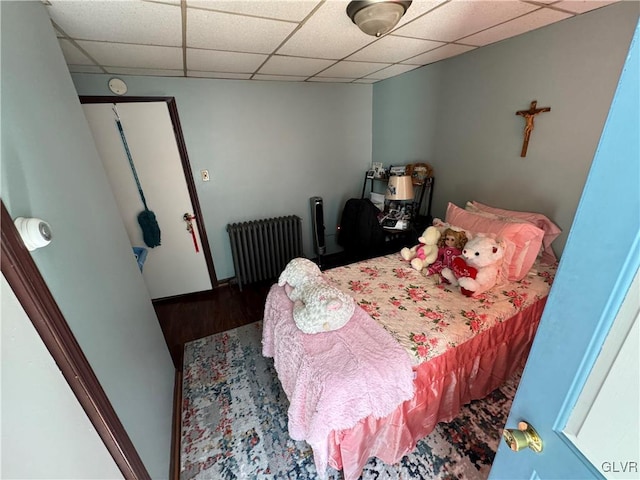 bedroom featuring radiator heating unit and wood-type flooring