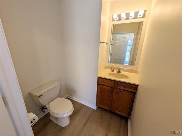 bathroom featuring toilet, hardwood / wood-style flooring, and vanity