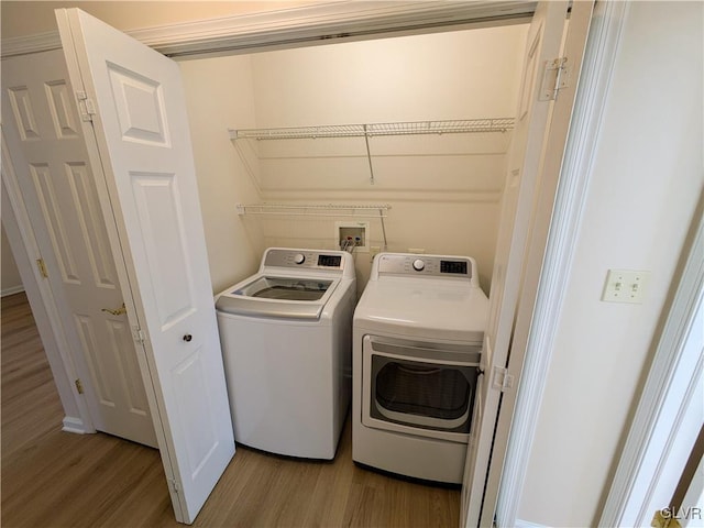 laundry area featuring light wood-type flooring and washing machine and clothes dryer