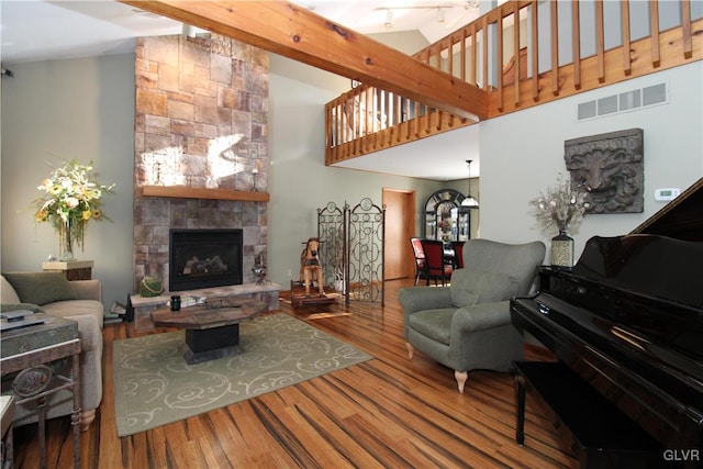 living room with a fireplace, high vaulted ceiling, and hardwood / wood-style flooring