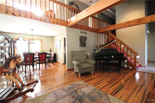 living room featuring a high ceiling and hardwood / wood-style flooring