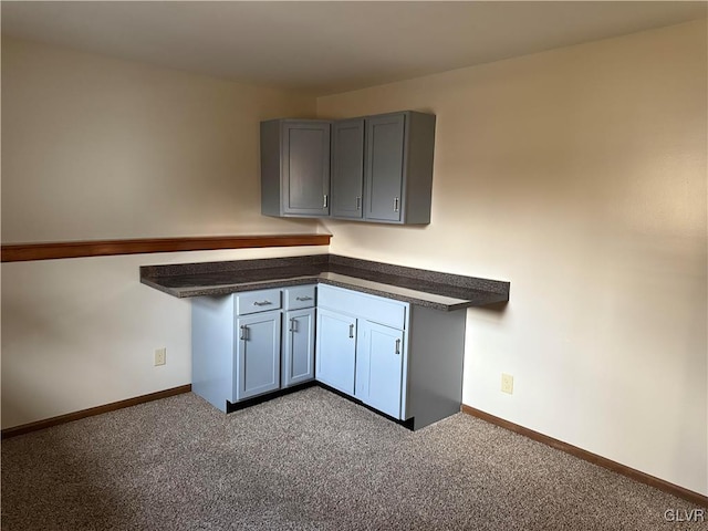 kitchen featuring light colored carpet and gray cabinetry