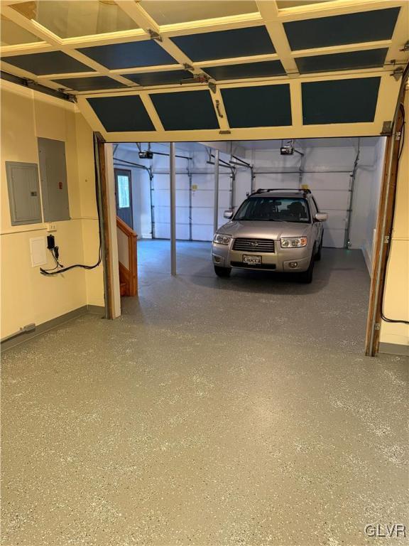 garage featuring electric panel and a garage door opener