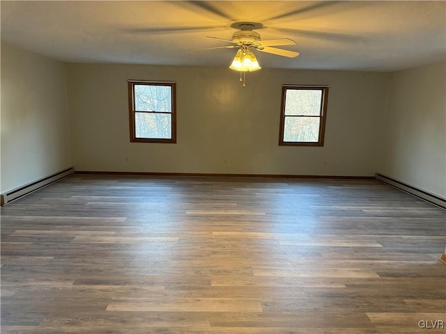 spare room with hardwood / wood-style flooring, ceiling fan, and a baseboard heating unit