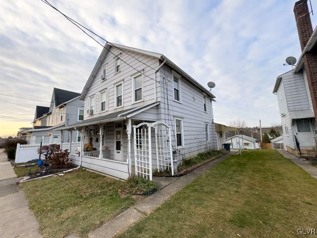 view of front of property with a lawn and a porch