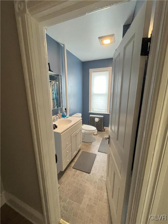 bathroom featuring radiator, vanity, and toilet