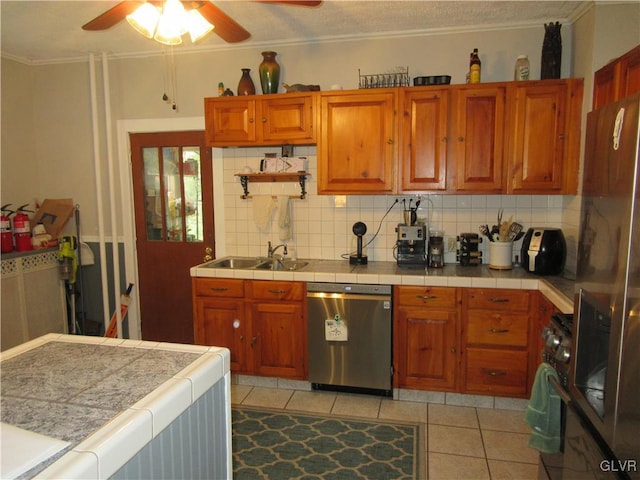 kitchen with tasteful backsplash, sink, light tile patterned floors, and stainless steel appliances