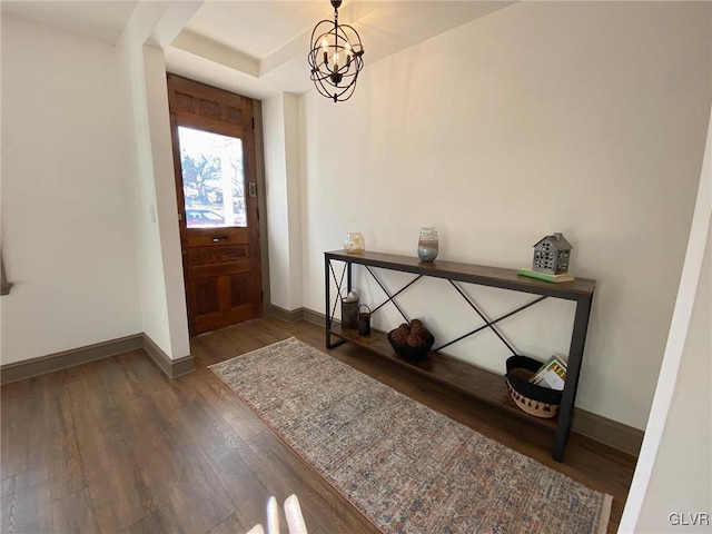 entrance foyer featuring an inviting chandelier and dark wood-type flooring