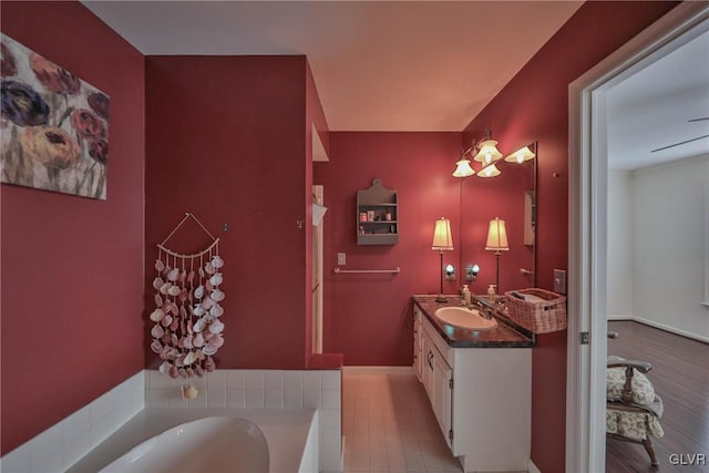 bathroom featuring vanity and tiled bath