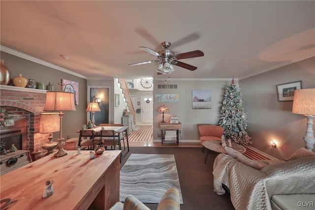 living room featuring ceiling fan, crown molding, and a brick fireplace