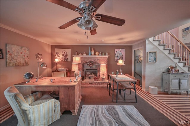 home office featuring a brick fireplace, ceiling fan, carpet floors, and ornamental molding