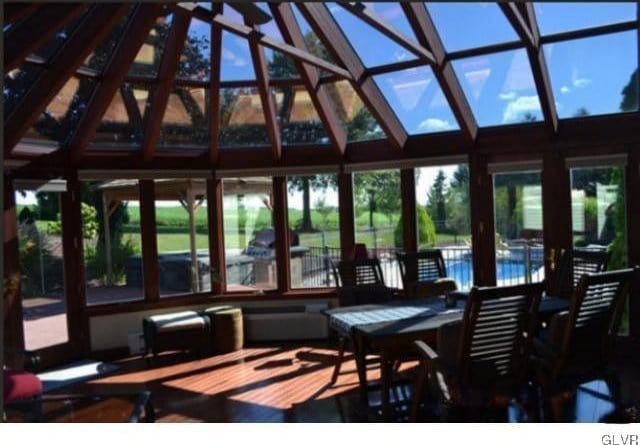 sunroom / solarium featuring vaulted ceiling and a healthy amount of sunlight