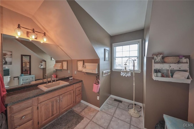 bathroom with tile patterned flooring, vanity, and lofted ceiling