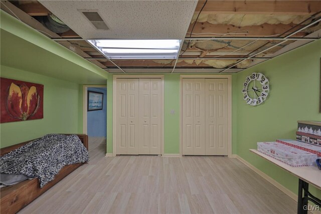 interior space with two closets and light hardwood / wood-style flooring