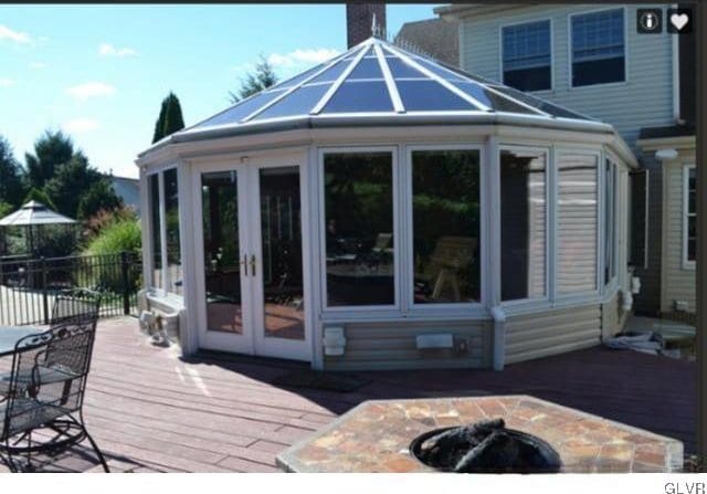 back of house with a wooden deck, french doors, and a fire pit