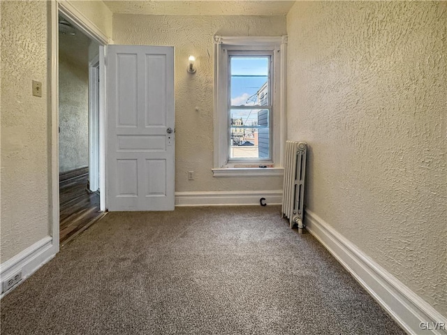 unfurnished room with carpet flooring and radiator heating unit