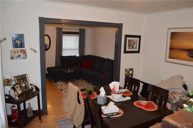 dining space with light hardwood / wood-style flooring and crown molding