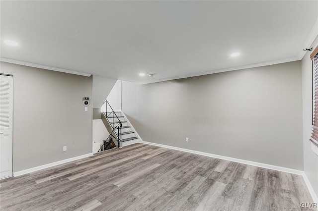 basement featuring light hardwood / wood-style floors and ornamental molding