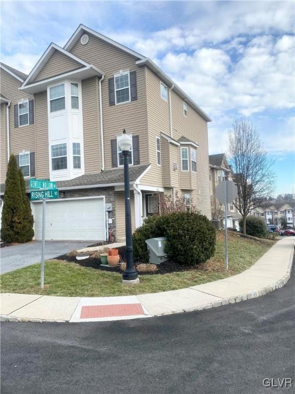 view of property featuring a front yard and a garage