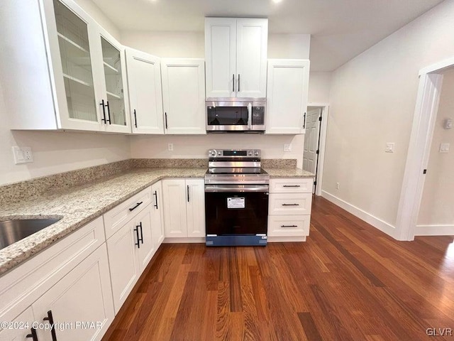 kitchen featuring light stone countertops, white cabinetry, stainless steel appliances, and dark hardwood / wood-style floors