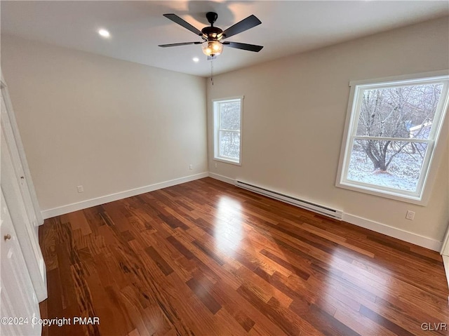 spare room featuring hardwood / wood-style floors, a wealth of natural light, a baseboard heating unit, and ceiling fan