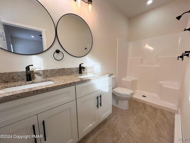 bathroom with tile patterned floors, vanity, toilet, and walk in shower