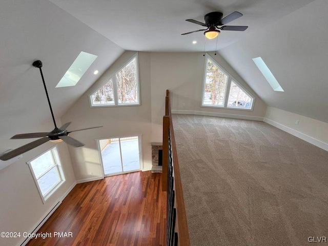 additional living space featuring ceiling fan, plenty of natural light, and lofted ceiling with skylight