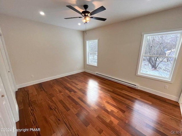 empty room featuring ceiling fan, wood-type flooring, and a baseboard heating unit