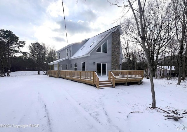 snow covered house featuring a deck