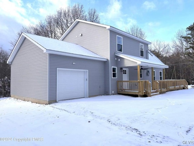 snow covered property featuring covered porch and a garage