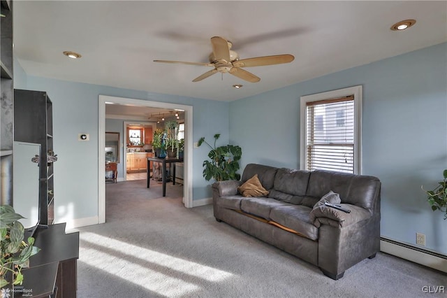 living room featuring baseboard heating, ceiling fan, and carpet