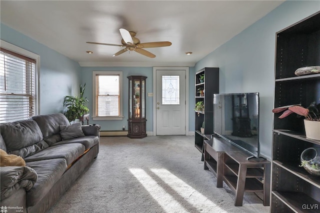 living room featuring baseboard heating, light carpet, and ceiling fan