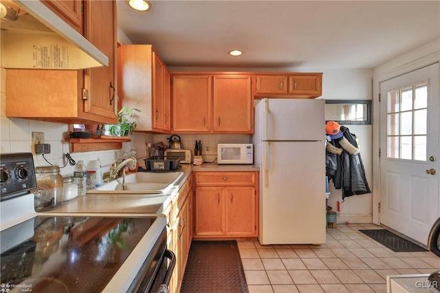 kitchen featuring light tile patterned flooring, white appliances, sink, and tasteful backsplash