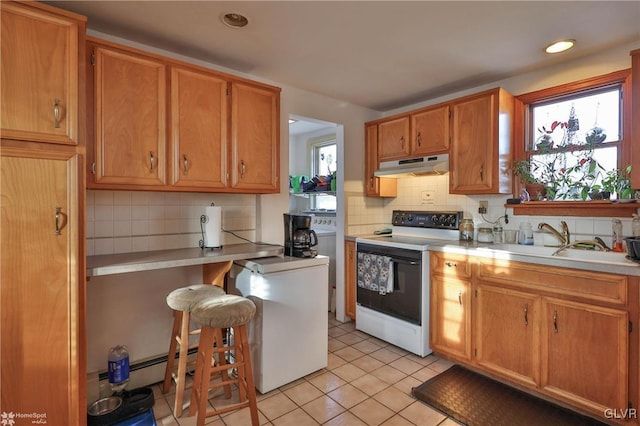 kitchen featuring a wealth of natural light, sink, light tile patterned flooring, and white electric stove