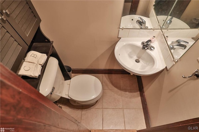 bathroom featuring tile patterned flooring, toilet, and sink