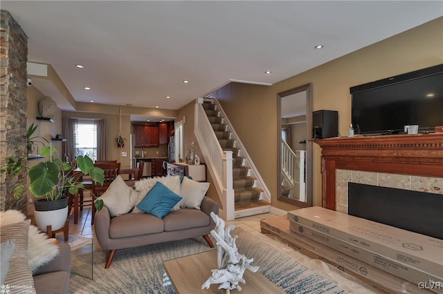 living room with a stone fireplace and light tile patterned floors