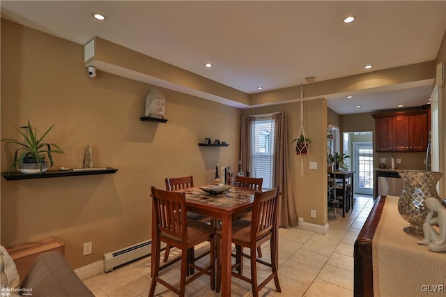 dining space with light tile patterned floors, baseboard heating, and a healthy amount of sunlight