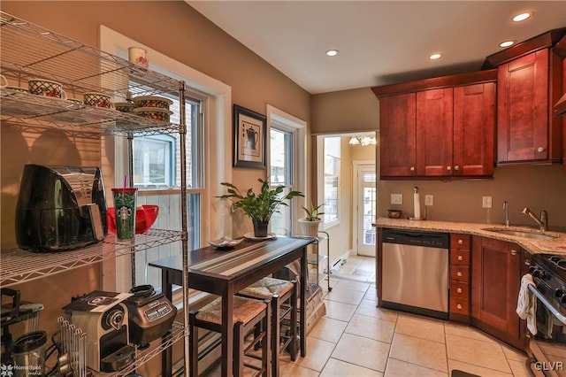 kitchen with light stone counters, stainless steel dishwasher, black range with gas stovetop, sink, and light tile patterned floors